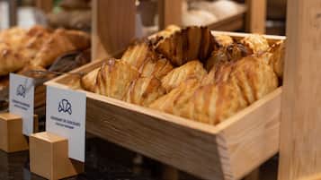 A display of croissants in a wooden box with a sign indicating they are chocolate croissants.