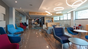 A modern hotel lobby with a bar area, seating arrangements, and a clear view of the bar.