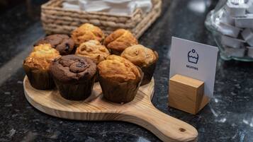 Uma tábua de madeira com muffins e uma placa com a inscrição 'MUFFINS'.