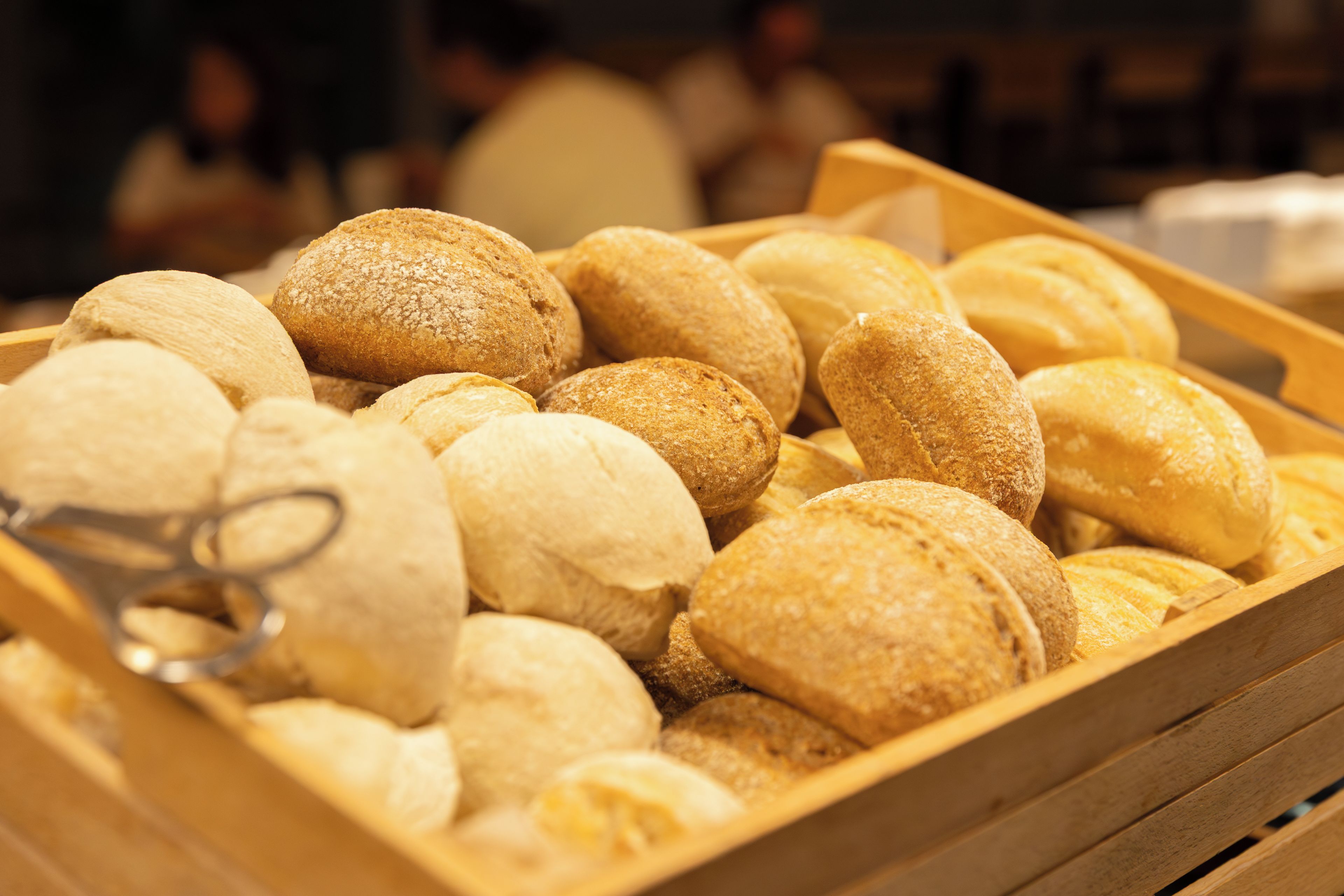 A wooden crate filled with various types of bread.