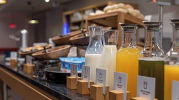 A beverage station with various drinks and wooden blocks with labels.