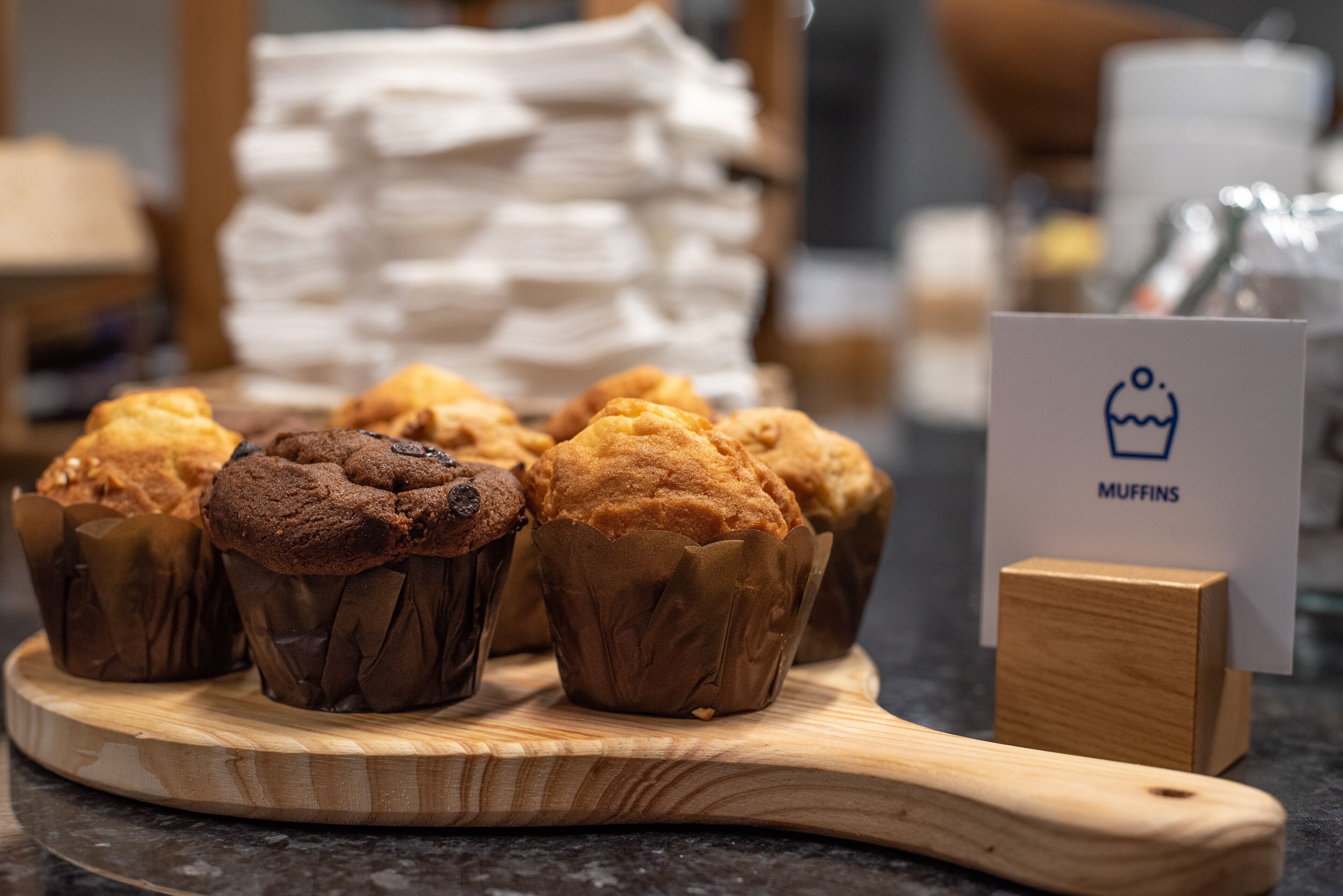 Una tabla de madera con muffins y un cartel que dice "MUFFINS".