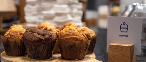 Una tabla de madera con muffins y un cartel que dice "MUFFINS".