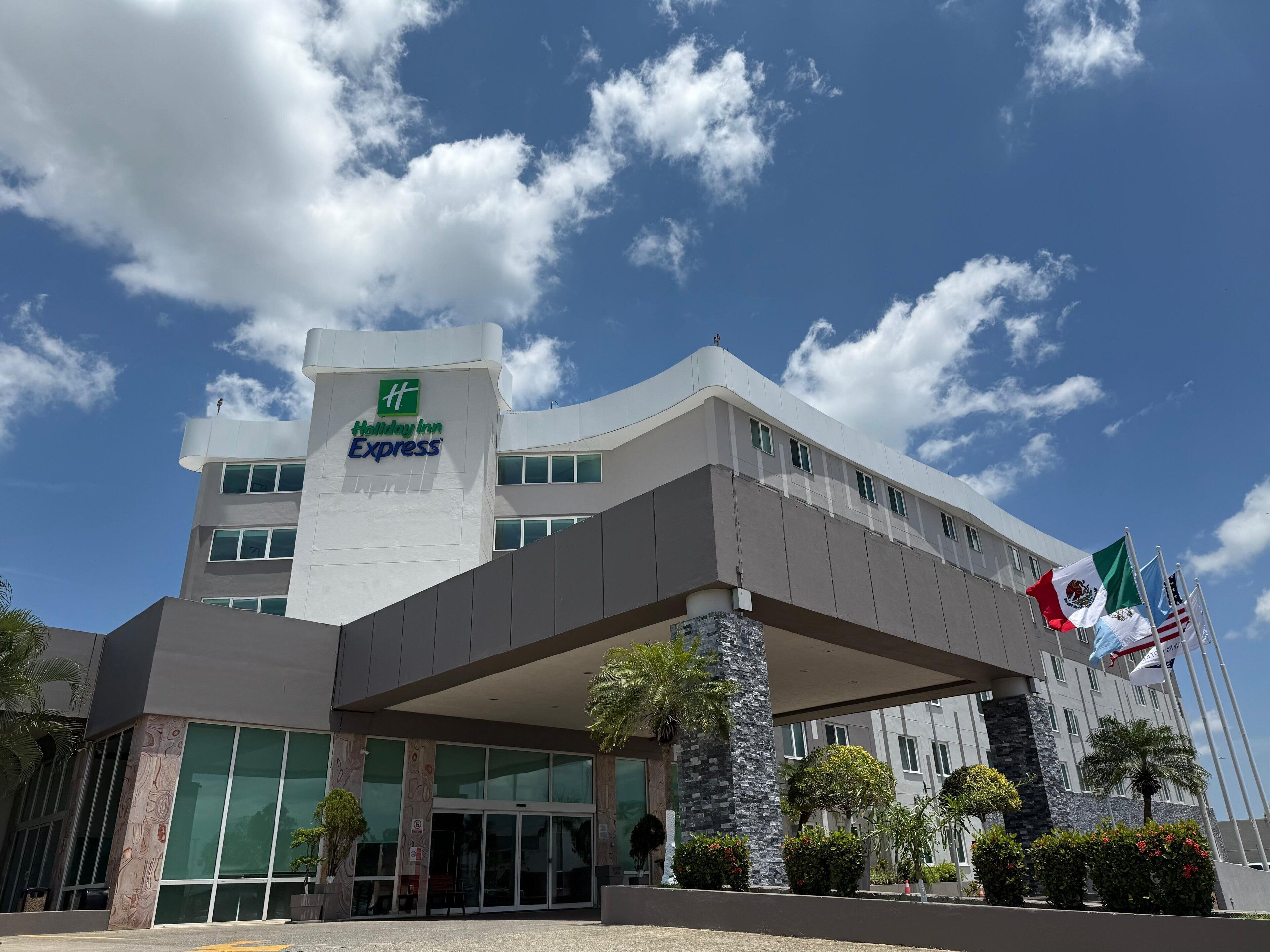 Un edificio de Holiday Inn Express con un diseño moderno, amplias ventanas y una entrada destacada.