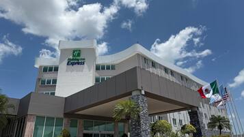 Un edificio de Holiday Inn Express con un diseño moderno, amplias ventanas y una entrada destacada.