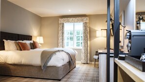 A hotel room with a bed, a desk, a chair, and a window with curtains. - The Princess Royal (Farnham)