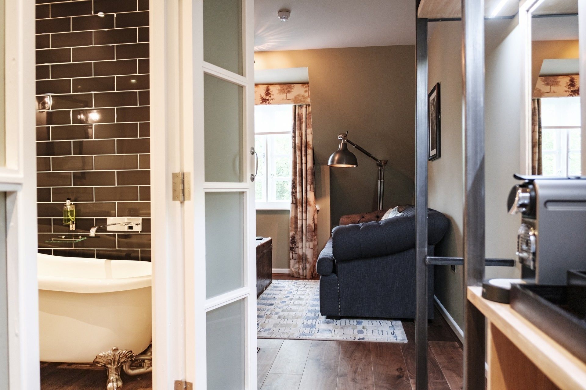 A bathroom with a bathtub, a mirror, and a towel rack.