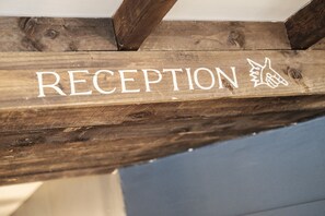 A wooden sign with the word "RECEPTION" and a handprint symbol.