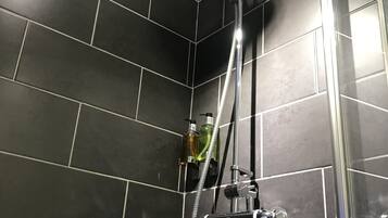 Ducha con cabezal de ducha de mano, cabezal de ducha empotrado y boquilla de masaje manual.
