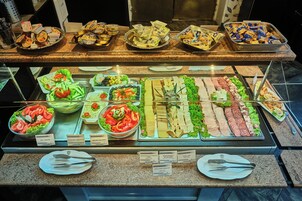 Un bufé con diversos alimentos y utensilios.
