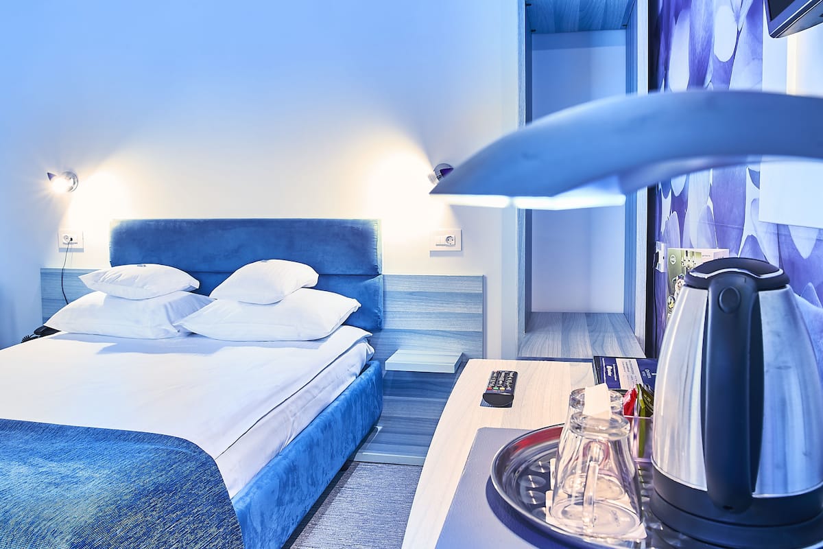 Ein Hotelzimmer mit Bett, Nachttisch und Wasserkocher.
