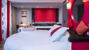 A modern hotel room with a large bed, a desk with a kettle, and a red accent wall. - Carrion Cuisine Hôtel & Spa (Vire)