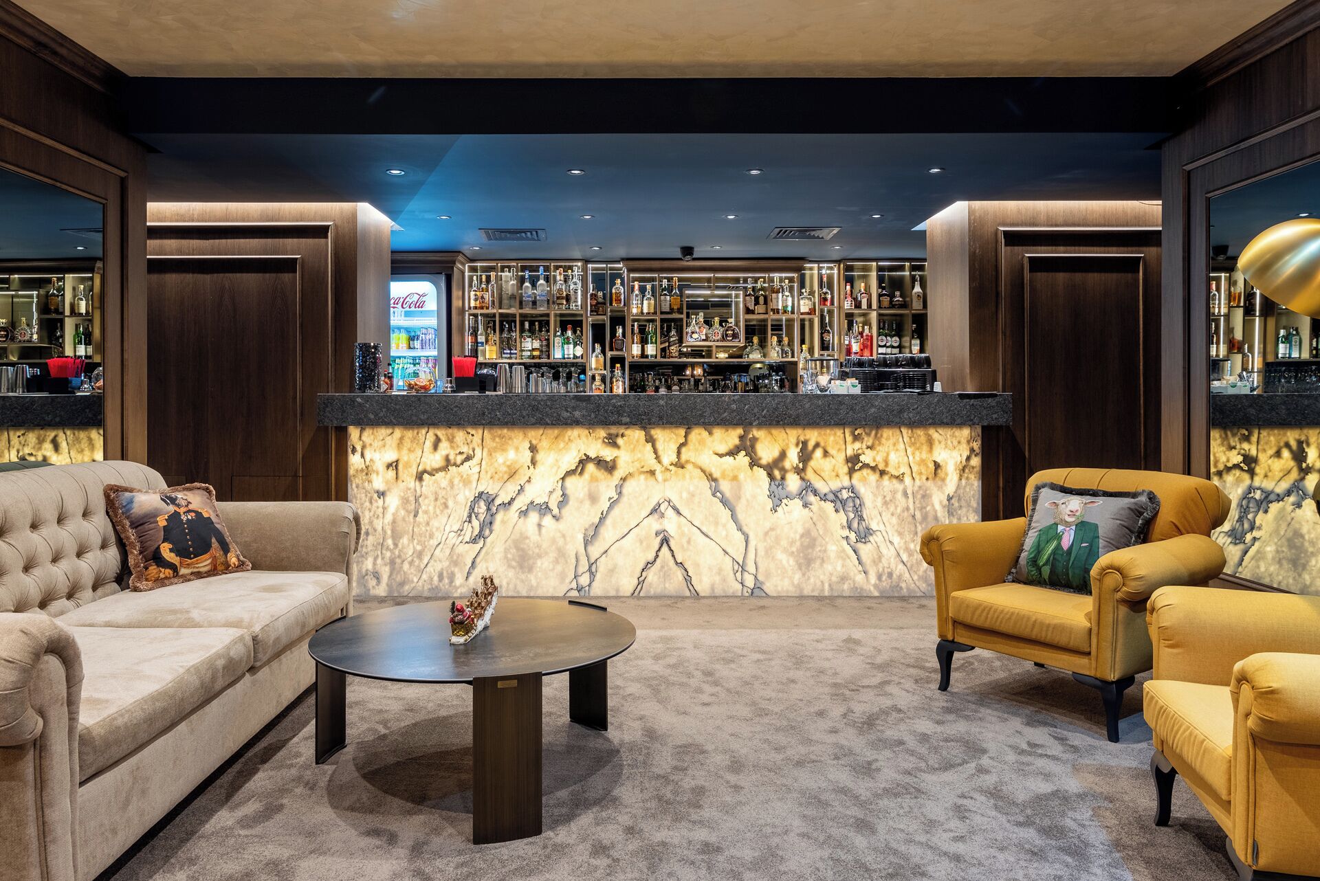 A bar area with a marble counter, two sofas, and a coffee table.