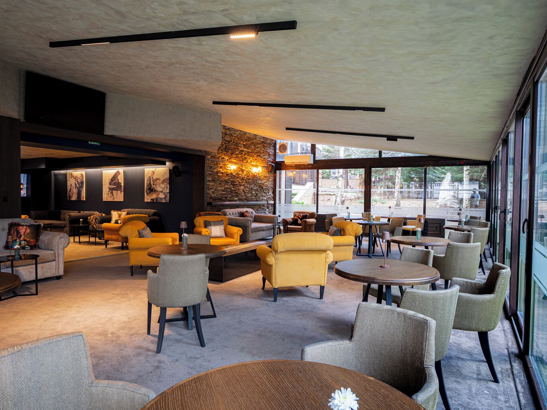 A modern lounge area with sofas, tables, and a stone accent wall.