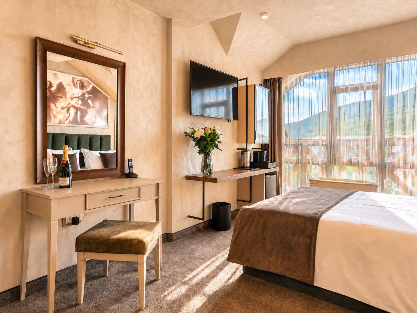 Habitación de hotel con cama, escritorio con teléfono, televisor, ventana con vista y un cuadro en la pared.