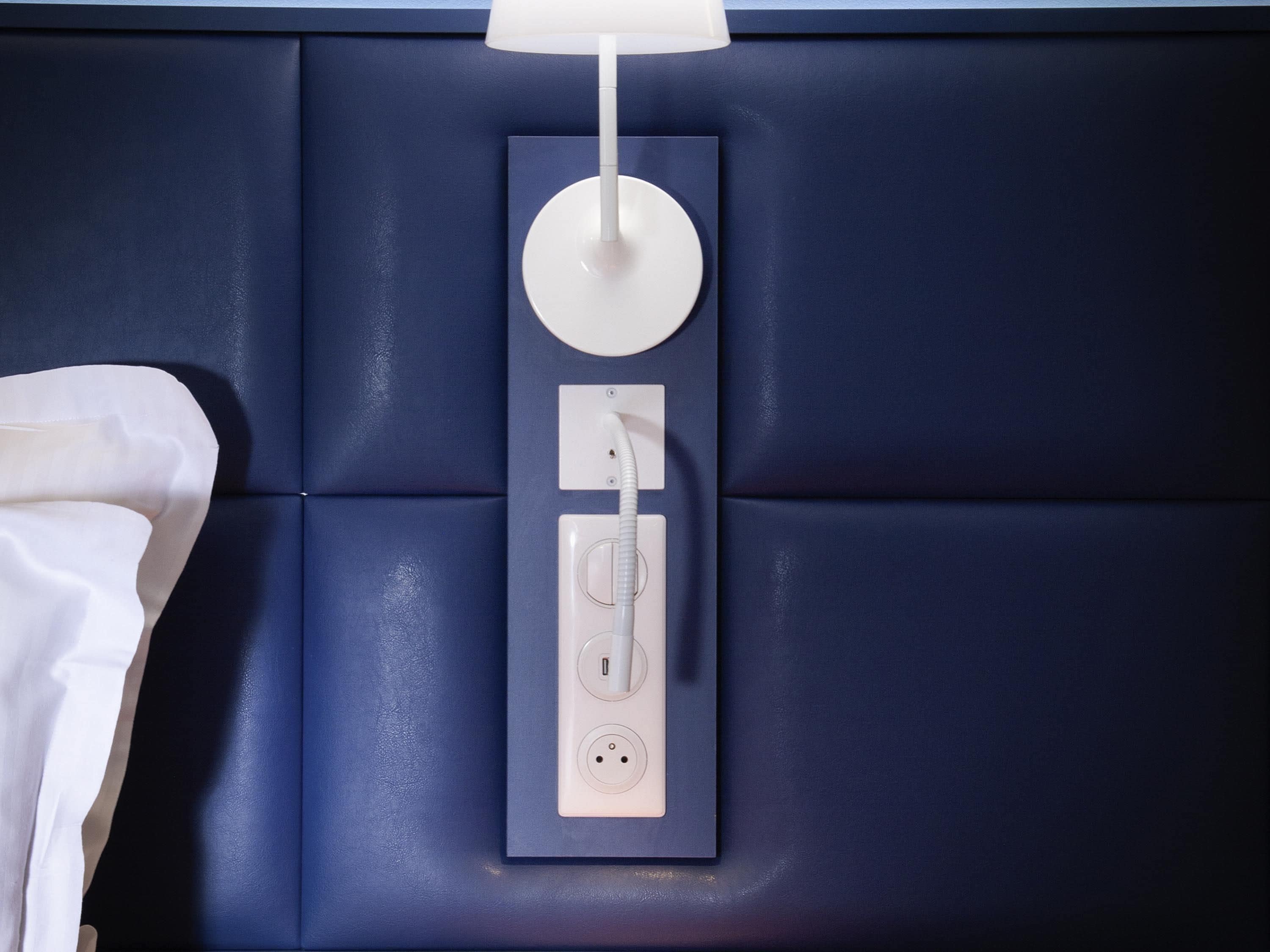 Una lámpara de pared con diseño circular, un enchufe y un interruptor.