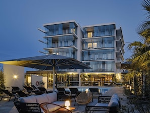 A modern hotel with a pool, lounge chairs, and a covered seating area. - Hôtel Mercure Toulon La Seyne-Sur-Mer (La Seyne-sur-Mer)