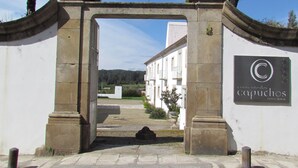 A stone archway leading to a building with a sign that reads "Convento dos Capuchos." - Convento dos Capuchos (Monção)