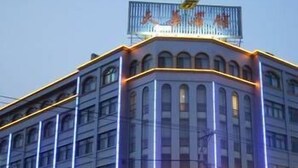 Un edificio de varios pisos con un letrero llamativo en la parte superior.