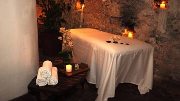 Experience a serene spa setting with a tranquil ambiance, featuring a meditation area with a candlelit table and a peaceful stone backdrop.