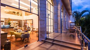 A modern hotel lobby with a spacious seating area, a staircase leading to an upper level, and a view of the outdoors. - Hotel Dann Carlton Bucaramanga (Bucaramanga)