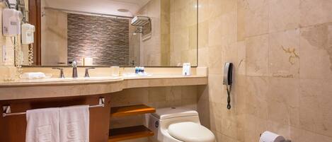 A modern bathroom with a vanity, a toilet, a shower, and a telephone.