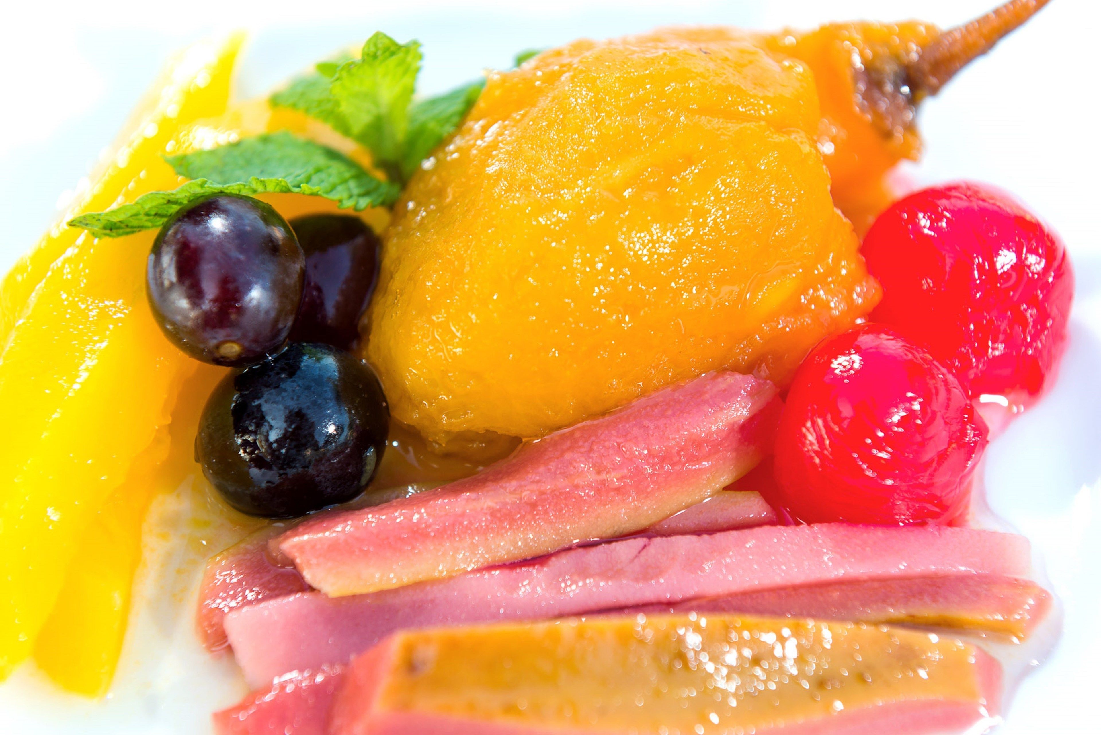 Una bandeja con frutas y quesos, incluyendo diversas frutas y rebanadas de queso.