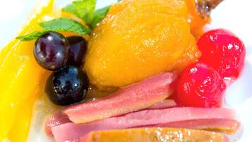 Una bandeja con frutas y quesos, incluyendo diversas frutas y rebanadas de queso.