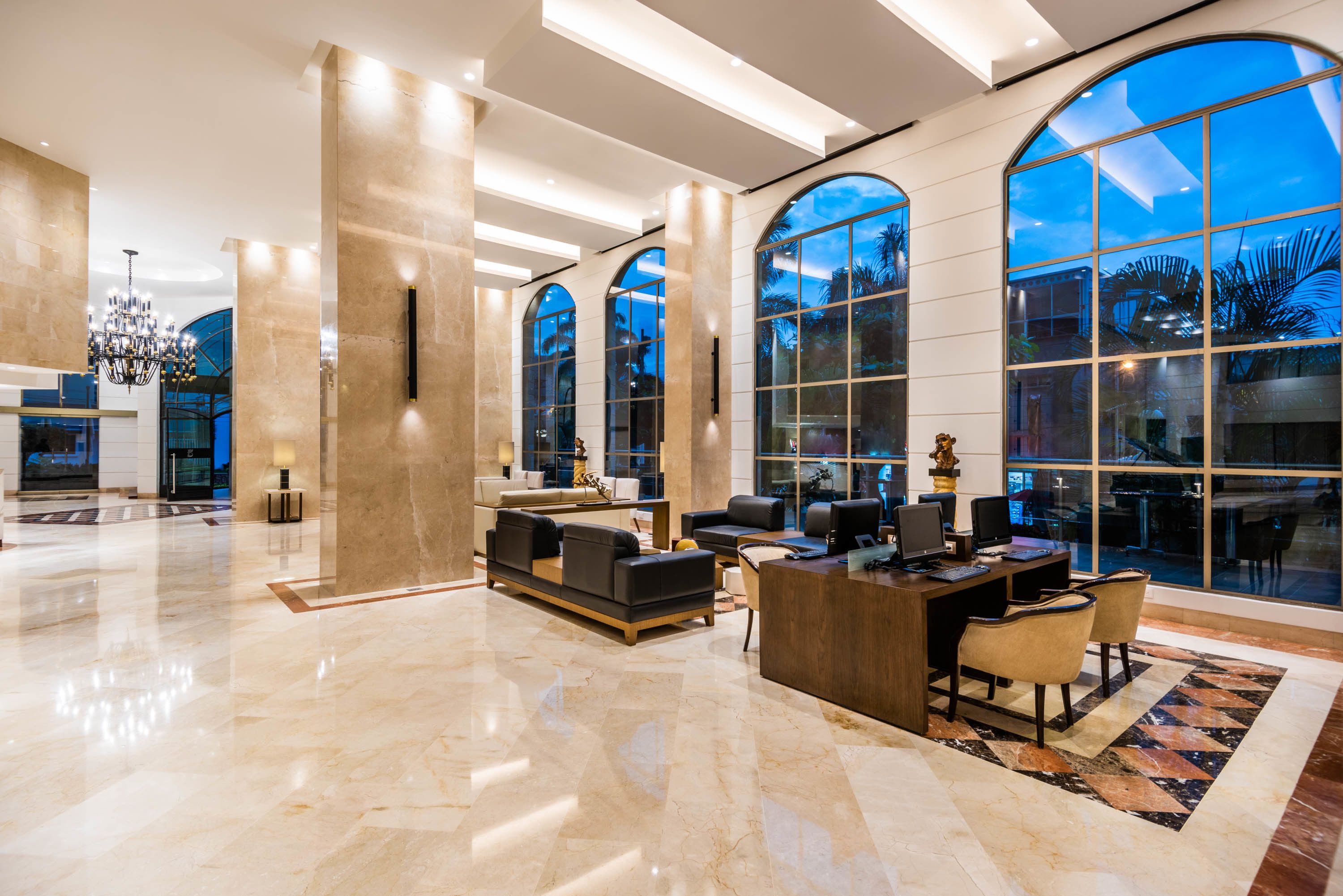 A spacious lobby with a reception desk, comfortable seating, and large windows offering views of the outdoors.