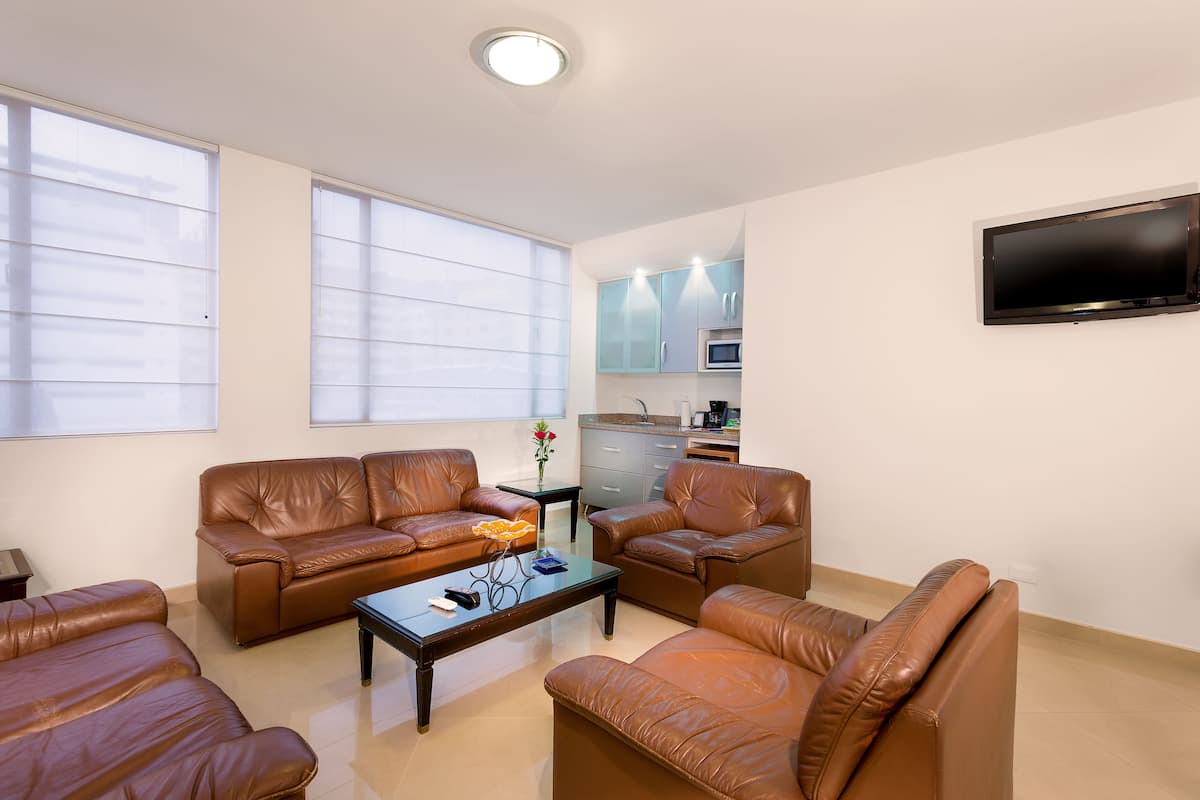 Suite junior, 1 cama Queen size y sofá cama | Sala de estar | Televisión LCD de 26 pulgadas con canales por cable y televisión