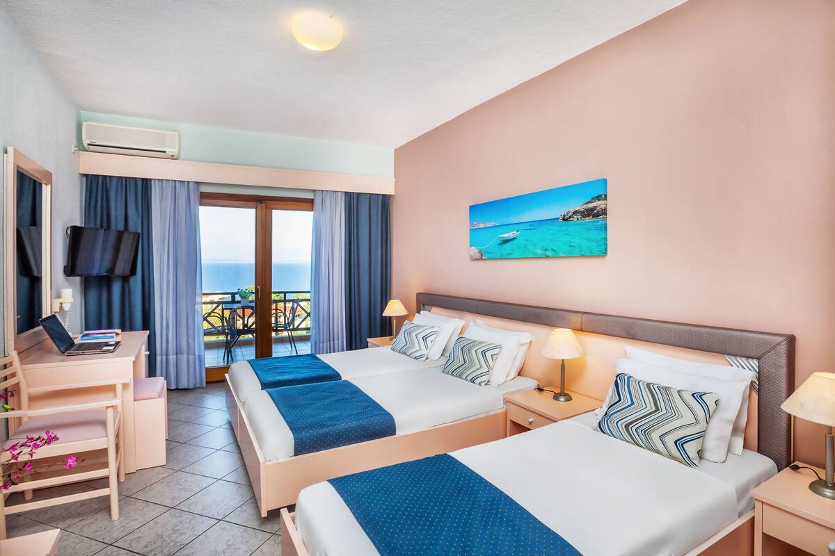 Ein Hotelzimmer mit zwei Betten, einem Schreibtisch, einem Stuhl und einem Fernseher.