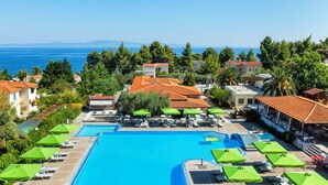 A resort with a large swimming pool, lounge chairs, and umbrellas. - Palladium Hotel (Kassandra)