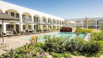 Relax by the pool surrounded by lush greenery and enjoy the hotel's lounge areas.