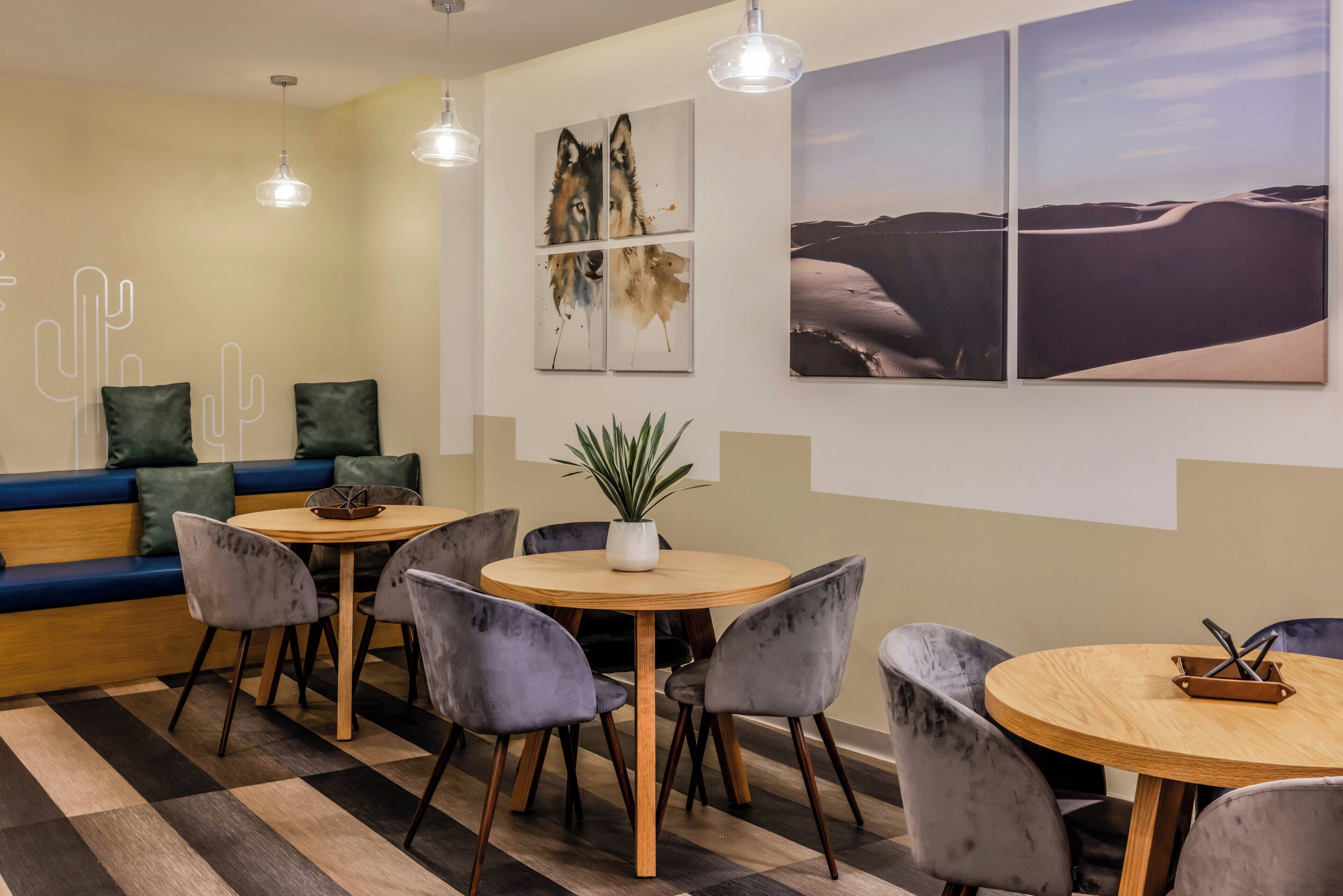 A modern lounge area with a sofa, round tables, and chairs.
