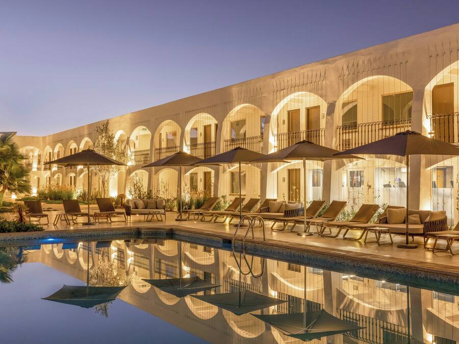A poolside area with lounge chairs and umbrellas, reflecting the building's architecture.
