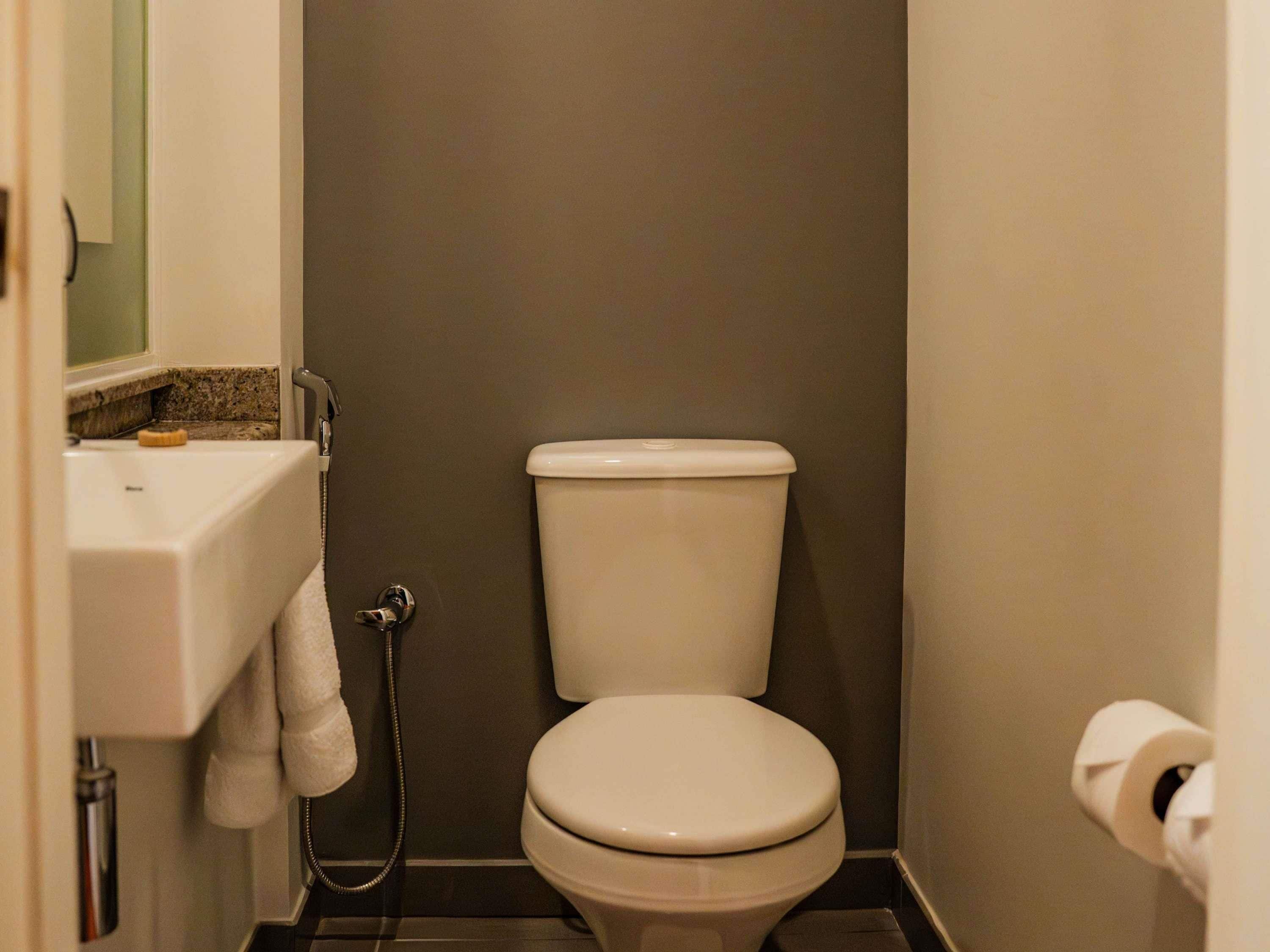 A small bathroom with a toilet, a sink, and a shower.