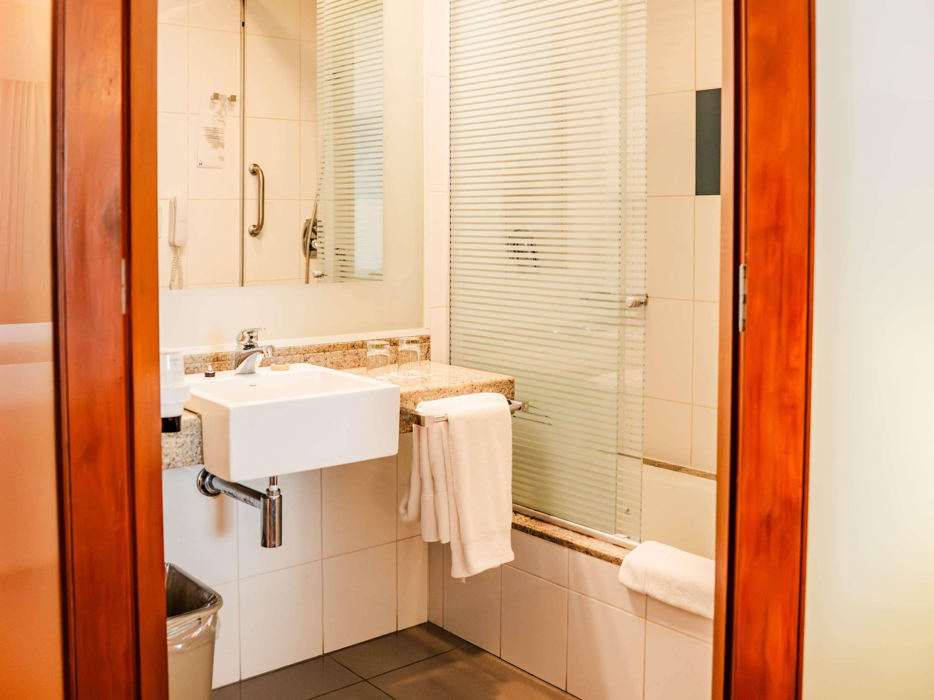 Un baño con lavamanos, espejo y ducha.