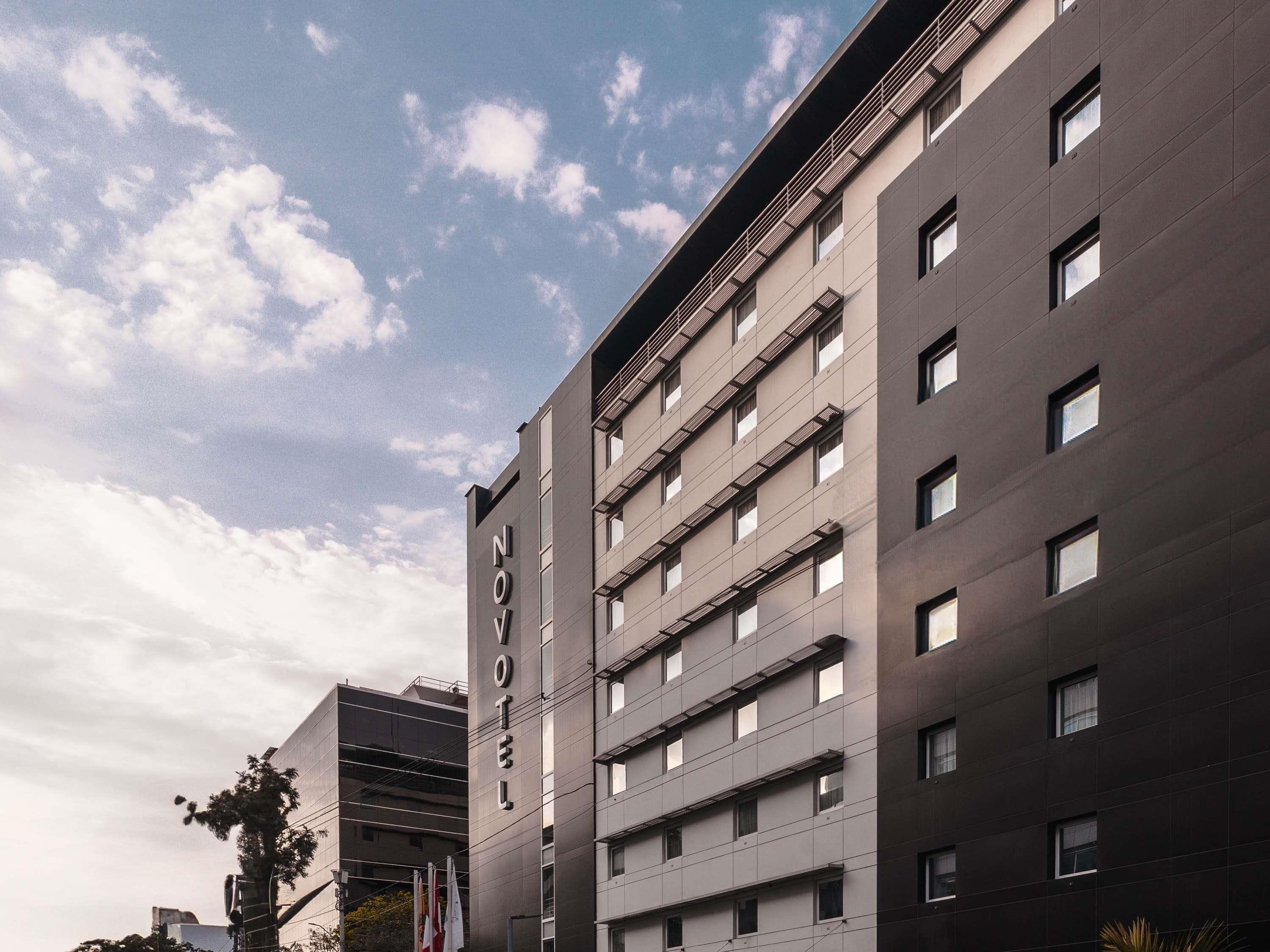 A modern hotel with a flat facade, multiple windows, and a visible name sign.