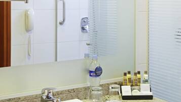 A bathroom with a sink, mirror, and shower.