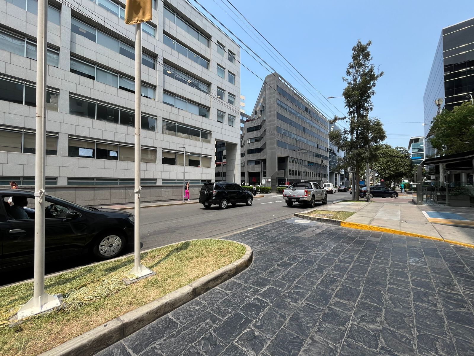 A street with modern buildings, a sidewalk, and a crosswalk.