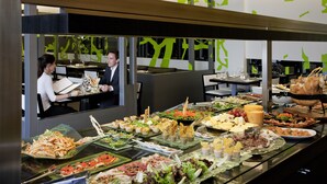 A buffet with various food items and a waiter serving. - Novotel Buenos Aires (Buenos Aires)
