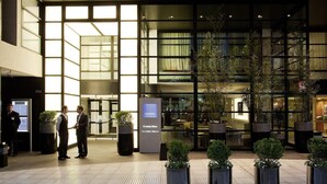 A hotel lobby with large windows, potted plants, and a reception area. - Novotel Buenos Aires (Buenos Aires)