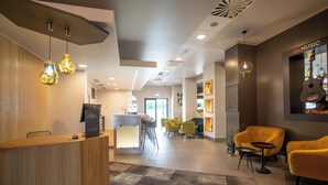 A modern hotel lobby with a reception desk, seating area, and a music-themed wall. - ibis Plzen (Plzen)