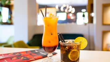 Duas bebidas sobre uma mesa, com um menu e fundo desfocado.