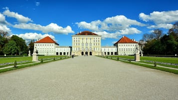 A large, symmetrical building with a central entrance and two wings, surrounded by well-manicured lawns and trees.