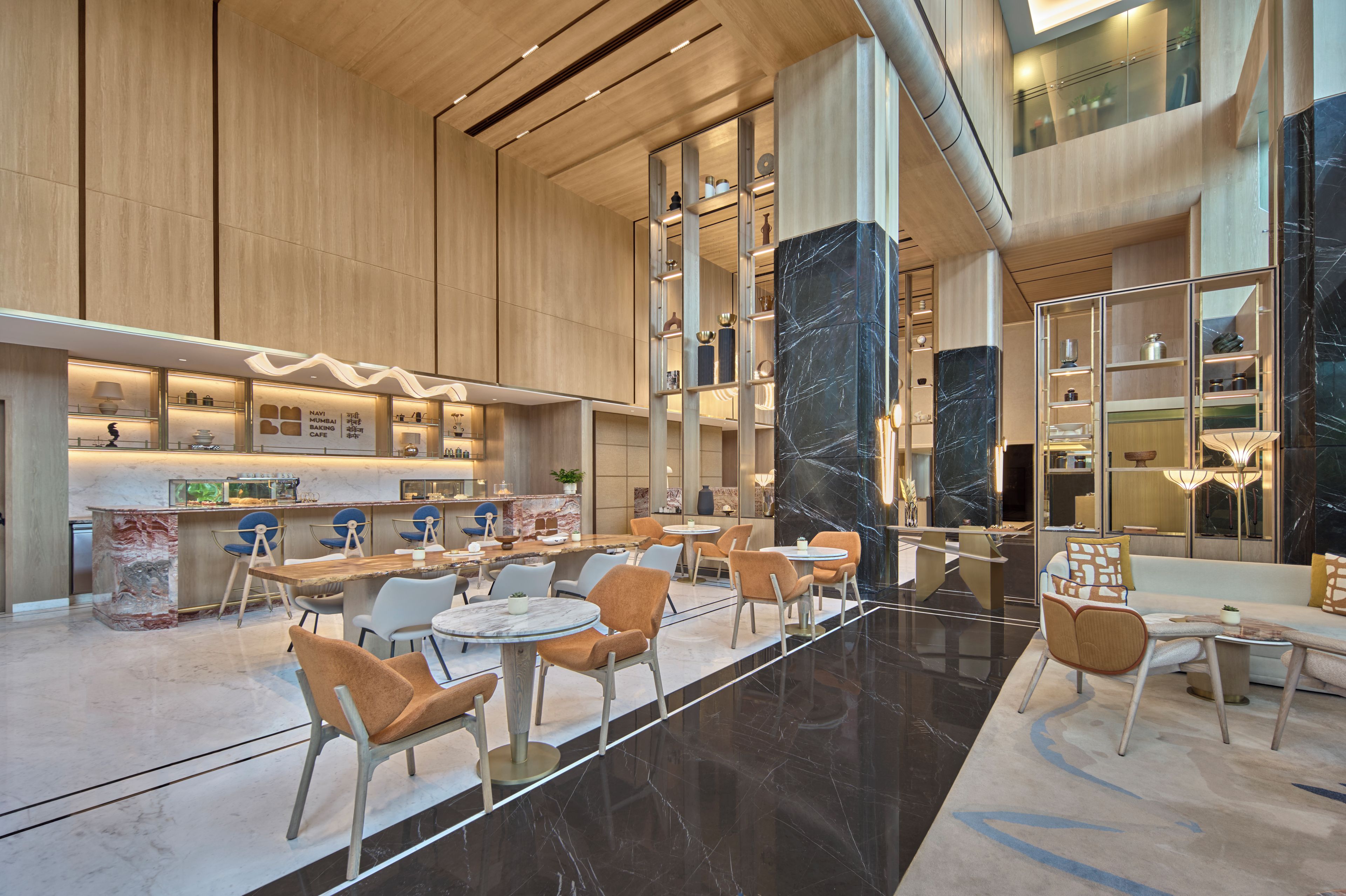 A spacious lobby with a central bar area, seating arrangements, and a marble column.
