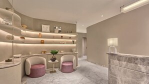 A modern bathroom with a curved design, marble flooring, and a central island with a plant. - Athiva Pulse Navi Mumbai, Autograph Collection (Navi Mumbai)