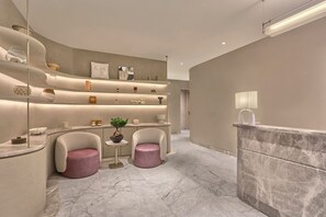 Un baño moderno con diseño curvo, suelo de mármol y una isla central con una planta.