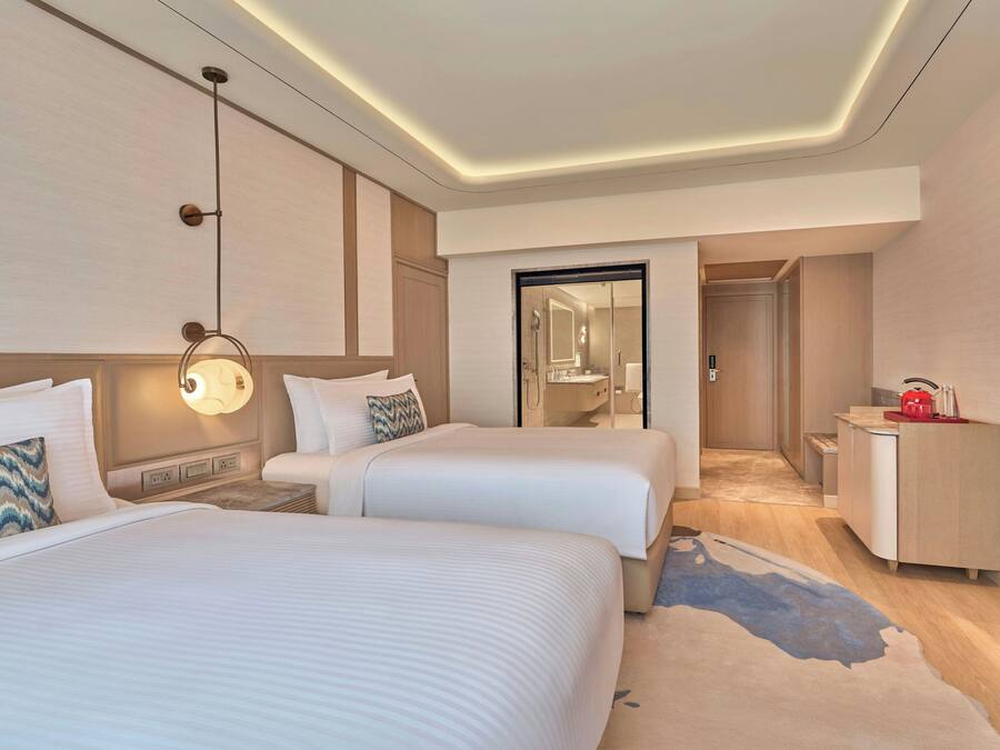Una habitación de hotel con dos camas, un baño y una kitchenette.