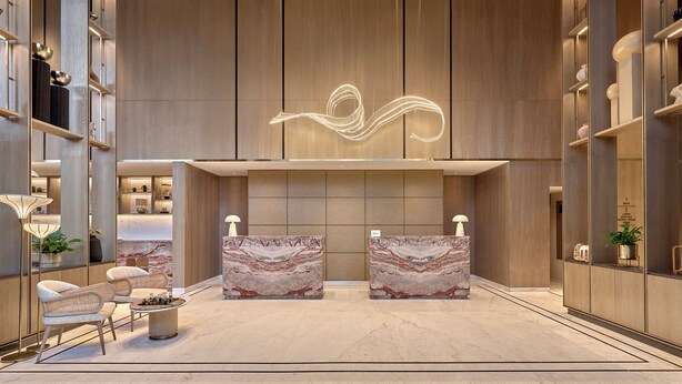 A modern lobby with marble reception desks, a unique light installation, and a seating area with a round table. - Athiva Pulse Navi Mumbai, Autograph Collection (Navi Mumbai)
